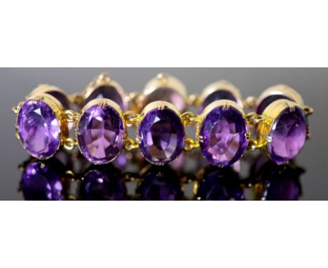 A Victorian style gold and ten stone oval cut amethyst set bracelet, 18.5cm, gross 64.9 grams.CONDITION: There are numerous l