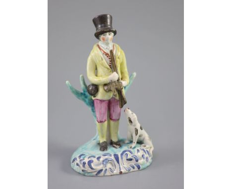 A Staffordshire pearlware group of a huntsman with dog and gun, c.1820-30, on a turquoise and blue highlighted scrollwork bas