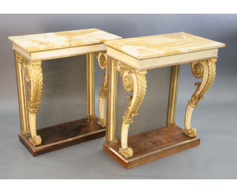 A pair of William IV parcel gilt cream painted and rosewood console tables, with later marble tops and brass grilled back pan