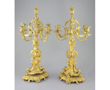 A pair of late 19th century French Louis XV style ormolu seven light candelabra, with foliate scroll branches and pierced ste