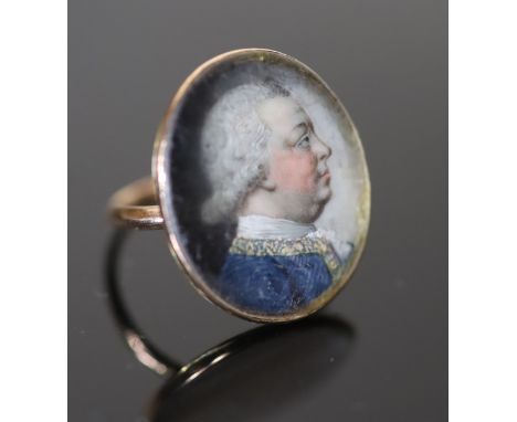 A George III gold and inset oval portrait miniature ring, painted with the bust of a gentleman to sinister, with glazed cover