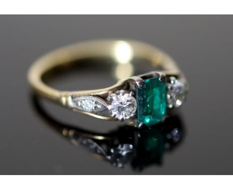 An 18ct gold, emerald and diamond set three stone ring, with diamond set shoulders, size M/N, gross 2.6 grams.CONDITION: Smal