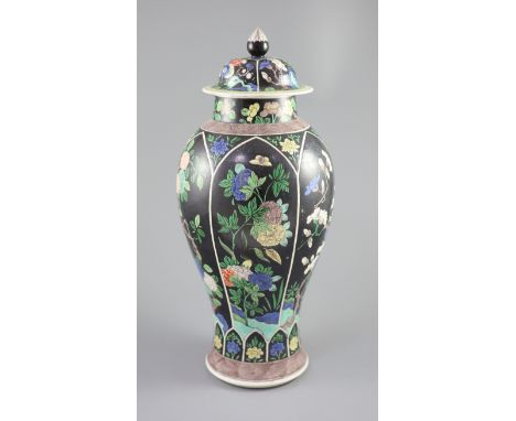 A Chinese famille noire enamelled biscuit baluster vase and cover, 19th century, decorated in Kangxi style with panels of blo