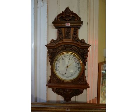 A Victorian carved walnut aneroid wall barometer,&nbsp;83.5cm high.&nbsp; 