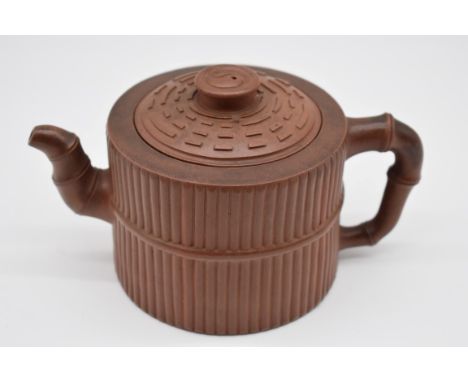 A Chinese yixing teapot and cover, seal mark to base and interior of lid, moulded with bamboo decoration, 10.5cm high. 