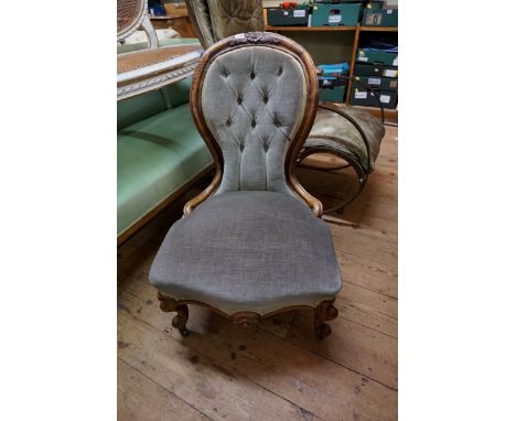 A Victorian carved walnut and button upholstered nursing chair. 