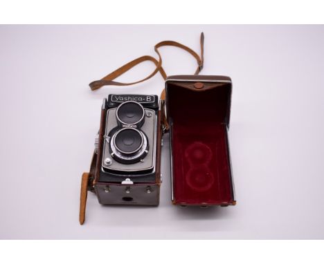 A Yashica-B camera, with Yashikor 1:3.5 f=80mm lens, no.495302, with Yashica lens cap and brown leather base. 