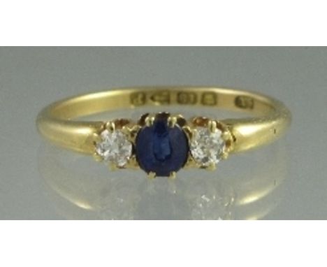 A VICTORIAN SAPPHIRE AND DIAMOND THREE STONE RING. The central mid-blue sapphire having an old cut diamond to either side. Ma