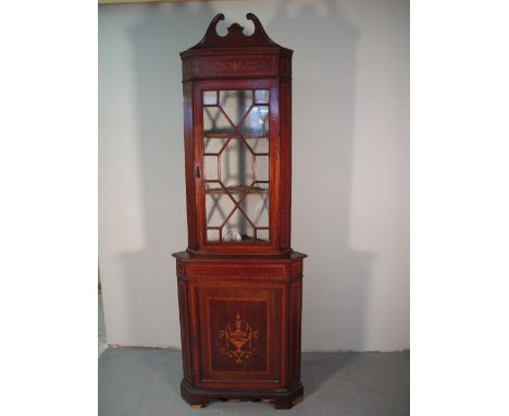 EDWARDIAN INLAID MAHOGANY TWO STAGE CORNER CABINET with projecting cupboard base, having broken swan neck pediment above foli