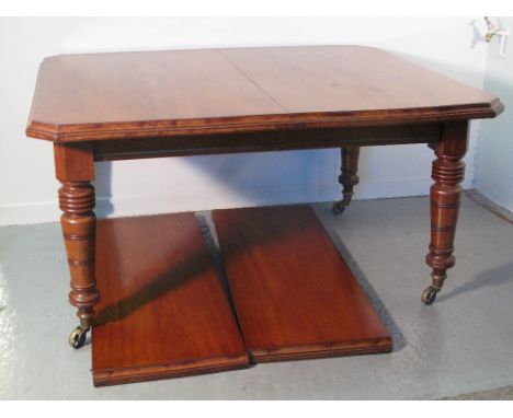 LATE 19TH CENTURY MAHOGANY WIND OUT EXTENDING DINING TABLE the top with moulded edge and canted angles, on ring and baluster 