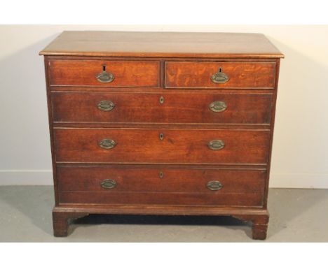 LATE GEORGIAN OAK STRAIGHT FRONTED CHEST of two short and three long graduated and cock beaded drawers under a framed moulded