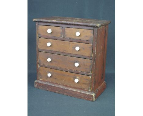 VICTORIAN STAINED PINE APPRENTICE PIECE CHEST OF TWO SHORT AND THREE LONG DRAWERS with knob ceramic handles on a platform bas