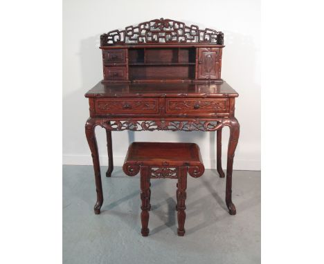 CHINESE HARDWOOD LADIES WRITING DESK with pierced gallery over pigeon holes, cupboard and drawers; the base with two foliate 