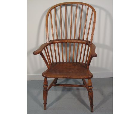 19TH CENTURY BEECH ASH AND ELM STICK BACKED WINDSOR FIRESIDE CHAIR having hoop shaped arms and moulded seat on baluster turne