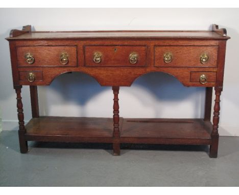 EARLY 19TH CENTURY SOUTH WALES OAK POTBOARD DRESSER, lacking its original rack but with the shoes, the base with three cock b