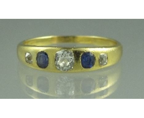 AN EDWARDIAN FIVE STONE SAPPHIRE AND DIAMOND RING. The unmarked yellow metal set with three old cut diamonds and two oval sap