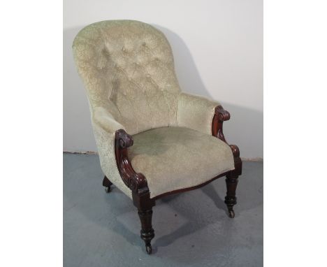 VICTORIAN MAHOGANY UPHOLSTERED FIRE SIDE EASY CHAIR having arched buttoned back, upholstered arms with scrolled moulded termi