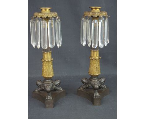 PAIR OF EARLY 19TH CENTURY BRONZE AND ORMOLU CANDLE STICK LUSTRES having pettalled sconces supporting prismatic cut lustres o