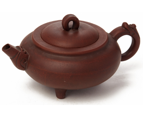 A COMPRESSED CIRCULAR YIXING POTTERY TEAPOT Impressed seal mark to base With dragon head handle, standing on three short feet