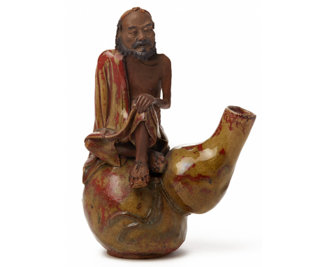 A '+D133:D134SHIWAN' POTTERY FIGURE OF A MAN SITTING ON A DOUBLE GOURD Perhaps early Qing period, according to the inventory 