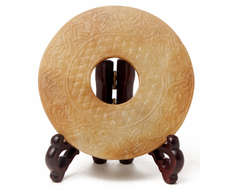 A CARVED JADE CEREMONIAL BI DISC The surface carved in shallow relief various borders, the reverse carved with a repeating pa