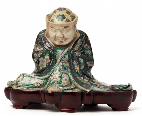 A 'FAMILLE VERTE' BISCUIT FIGURE OF A SEATED IMMORTAL Probably 19th century Impressed seal mark to base, on wood stand 16cm h