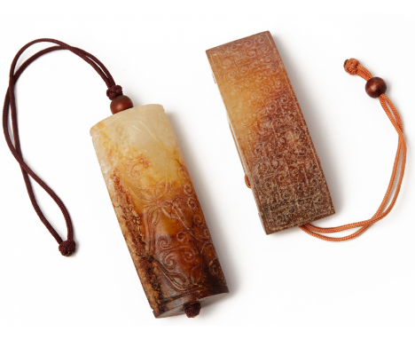 AN ARCHAISTIC CARVED JADE SWORD SLIDE AND A PENDANT Both of white and russet jade, the slide carved to the top surface in sha