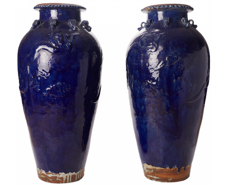 A PAIR OF LARGE BLUE GLAZED MARTABAN STORAGE JARS Relief decorated slender baluster body and reeded lug handles 84cm high x 3