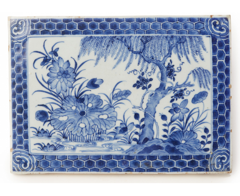 A BLUE AND WHITE RECTANGULAR PORCELAIN PLAQUE Painted with a garden scene within a honeycomb border with ruyi corners 24cm lo