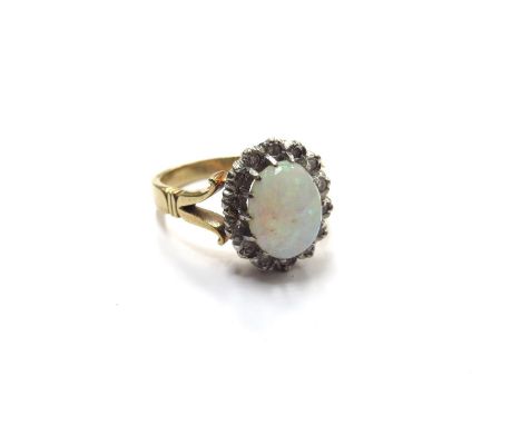 An opal and diamond ring, the opal 9mm x 7mm framed by diamonds, stamped 18ct. Size O, 5.8g 