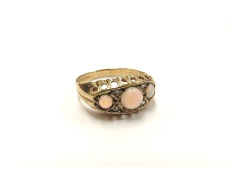 A 9ct gold opal and diamond chip ring, the three round opals spaced by diamond chips. Size I/J, 1.6g 