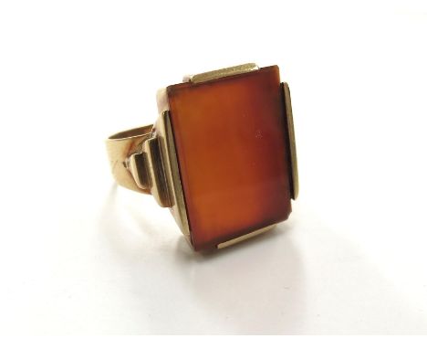 A gents gold ring set with a large cornelian panel in stepped mount, stamped 585. Size Y, 12.8g 