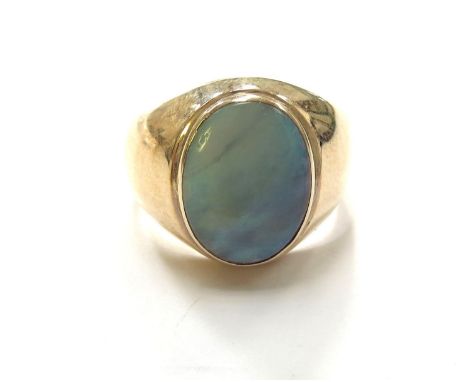 A gold signet ring with an oval opal in rub over setting, stamped 14k. Size U, 6g 
