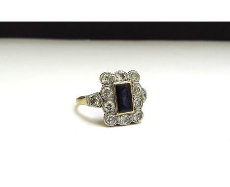 An 18ct/plat set Art Deco sapphire and diamond ring, the rectangular sapphire 7mm x 4mm framed by 10 x 0.08ct diamonds with d