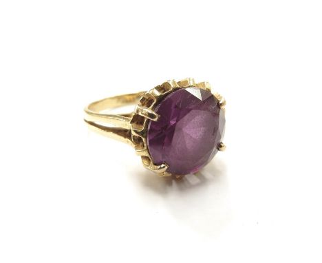 A yellow gold ring set with a large round cut amethyst, 12mm diameter, in four claw setting, marked 18k. Size N/O, 7.4g 