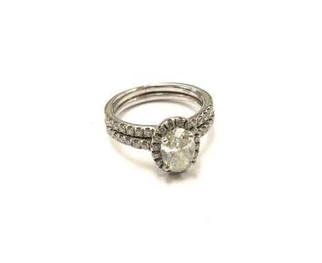 A platinum diamond set double band ring the centre oval diamond 0.75ct framed by diamonds. Size J, 6.7g 
