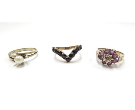 Three 9ct gold rings including a ruby and diamond chip floral example, size N, sapphire wishbone, size M/N and single pearl, 