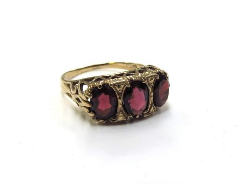 A 9ct gold three stone garnet ring. Size R, 3.2g 