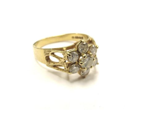 An 18ct gold diamond daisy ring, pierced shoulders. Size M, 4g 
