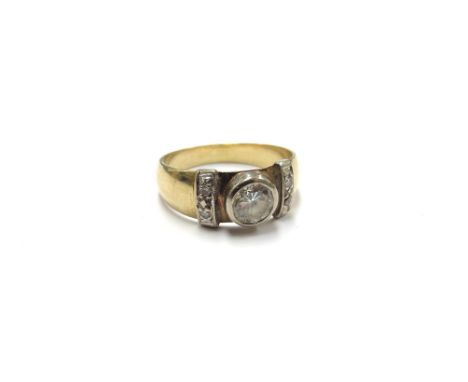 A gold ring centrally set with a 0.50ct approx diamond flanked by vertical diamond bands, stamped 18ct. Size N/O, 4.9g 