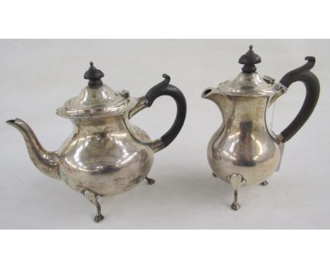 George V bachelor's silver teapot and matching hot water jug, having serpentine everted rim, ebonised finial and scroll handl