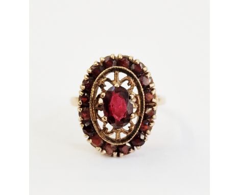 19th century 9ct gold and garnet ring, set centre oval facet-cut garnet in openwork setting and having surround of tiny garne