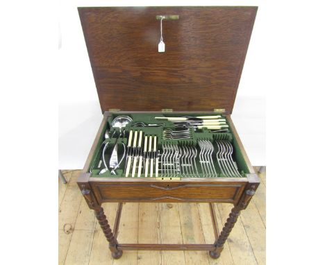 An oak canteen table on four barleytwist supports with stretchers, containing silver plated flatware service, six place setti