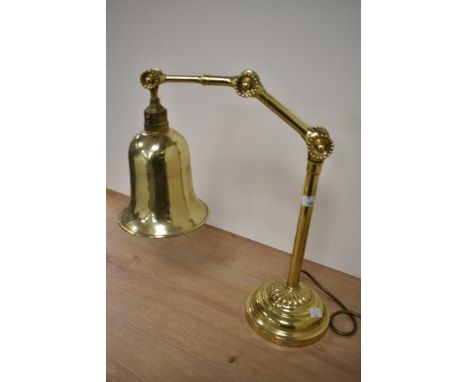 An Edwardian brass adjustable desk lamp, raised upon a stepped circular base, measuring 40cm tall