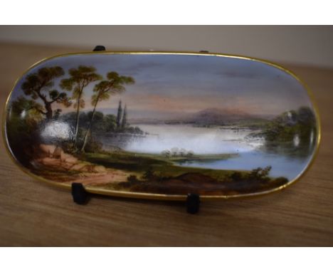 A 19th Century continental porcelain trinket dish, of elongated form, decorated with a sunlit lake scene, measuring 12cm long