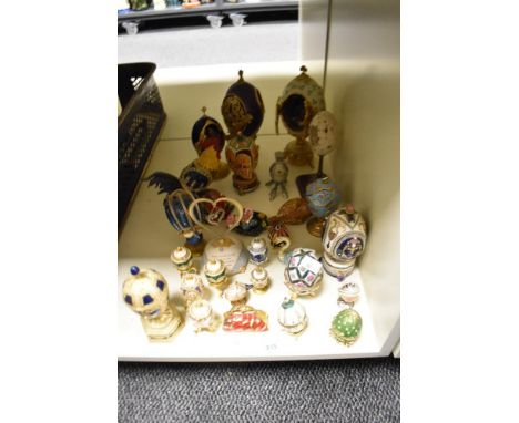 A collection of decorative ornamental egg shaped trinket boxes, some with scenes inside and similar items.