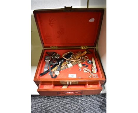 A large Chinese style wooden jewellery box containing a variety of costume jewellery including Casio wristwatches, a Celtic C