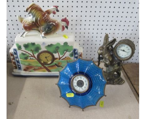 Three various clocks, to include a porcelain cased clock decorated with a rural scene surmounted with a cockerel and a hen, a
