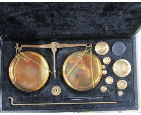 A cased set of brass balance scales