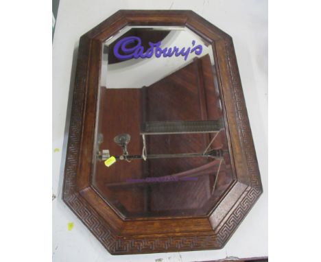 An oak framed wall mirror, decorated with Cadbury, together with two glasses decorated with the Cadbury glass and a half and 